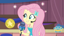 Size: 3410x1920 | Tagged: safe, screencap, fluttershy, best in show: the victory lap, equestria girls, g4, my little pony equestria girls: better together, best in show logo, female, geode of fauna, hairpin, jewelry, magical geodes, microphone, necklace, smiling, solo