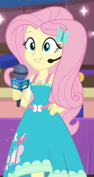 Size: 917x1725 | Tagged: safe, screencap, fluttershy, best in show: the victory lap, equestria girls, g4, my little pony equestria girls: better together, armpits, belt, clothes, cropped, cutie mark accessory, cutie mark on clothes, earpiece, eyeshadow, fluttershy boho dress, geode of fauna, grin, hairpin, hand on hip, jewelry, magical geodes, makeup, microphone, necklace, sleeveless, smiling, solo, teeth