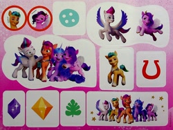 Size: 1858x1397 | Tagged: safe, egmont, hitch trailblazer, izzy moonbow, pipp petals, sunny starscout, zipp storm, earth pony, pegasus, pony, unicorn, g5, my little pony: a new generation, official, 3d, book, button, crystal, dreamworks face, flying, hug, male, mane five, merchandise, photo, proud, red eyes, smiling, stallion, sticker