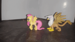 Size: 640x360 | Tagged: safe, artist:dex stewart, fluttershy, gilda, griffon, pegasus, pony, g4, animated, blind bag, chase, gif, irl, stare, stop motion, the stare, toy
