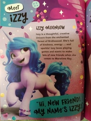 Size: 3120x4160 | Tagged: safe, izzy moonbow, pony, unicorn, g5, my little pony: a new generation, book, hi new friend, irl, my little pony annual 2022, photo