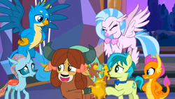 Size: 1600x900 | Tagged: safe, screencap, gallus, ocellus, sandbar, silverstream, smolder, yona, changedling, changeling, classical hippogriff, dragon, earth pony, griffon, hippogriff, pony, yak, g4, she's all yak, bow, bowtie, cloven hooves, dragoness, eyes closed, female, hair bow, hand on hip, jewelry, male, monkey swings, necklace, spread wings, student six, wings