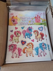 Size: 3000x4000 | Tagged: safe, izzy moonbow, pinkie pie, pony, unicorn, g5, box, castle, dollar tree, female, heart, irl, male, not izzy moonbow, not pinkie pie, photo, tattoo