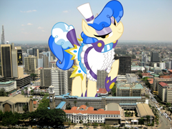 Size: 2048x1534 | Tagged: safe, artist:dashiesparkle, artist:thegiantponyfan, sapphire shores, earth pony, pony, g4, female, giant pony, giant sapphire shores, giant/macro earth pony, giantess, highrise ponies, irl, kenya, looking at you, macro, mare, mega giant, nairobi, photo, ponies in real life, raised hoof, smiling, solo