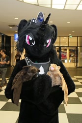Size: 600x900 | Tagged: safe, artist:atalonthedeer, oc, oc:midnight romance, alicorn, bat, human, anthro, g4, 2016, bat plushie, convention, convention:eurofurence, fursuit, gem, horn, irl, irl human, jewelry, lidded eyes, looking at you, magenta eyes, photo, plushie, ponysuit, solo, tiara, why can't i hold all these x