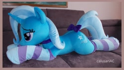 Size: 3952x2248 | Tagged: safe, artist:calusariac, trixie, pony, g4, bow, clothes, high res, irl, life size, lying down, photo, plushie, prone, socks, solo, striped socks, tail, tail bow