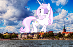 Size: 1920x1239 | Tagged: safe, artist:emu34b, artist:thegiantponyfan, fleur-de-lis, pony, unicorn, g4, female, finland, giant pony, giant unicorn, giantess, helsinki, highrise ponies, irl, looking at you, macro, mare, mega giant, one eye closed, photo, ponies in real life, raised leg, smiling, solo, wink
