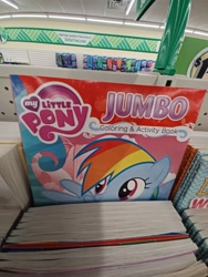 Size: 2448x3264 | Tagged: safe, rainbow dash, pegasus, pony, g4, coloring book, dollar tree, female, high res, irl, mare, my little pony jumbo coloring book, my little pony logo, open mouth, open smile, photo, raised hoof, smiling, solo, spread wings, wings