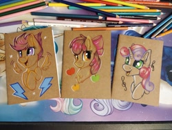 Size: 1152x864 | Tagged: safe, artist:julunis14, apple bloom, scootaloo, sweetie belle, earth pony, pegasus, pony, unicorn, g4, apple, apple bloom's bow, bow, bust, colored pencil drawing, cute, cutie mark crusaders, excited, female, filly, floating wings, foal, food, hair bow, music notes, notebook, open mouth, open smile, smiling, spread wings, traditional art, wings