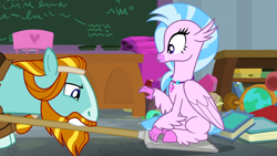 Size: 1920x1080 | Tagged: safe, screencap, rockhoof, silverstream, classical hippogriff, earth pony, hippogriff, pony, a rockhoof and a hard place, g4, season 8, chalkboard, classroom, colored hooves, desk, duo, female, jewelry, male, mare, necklace, rockhoof's shovel, shovel, sitting, sitting on shovel, stallion