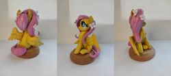 Size: 1813x808 | Tagged: safe, artist:anotherdeadrat, fluttershy, pegasus, pony, g4, craft, female, figurine, flower, flower in hair, irl, mare, photo, sculpture, sitting, smiling, solo