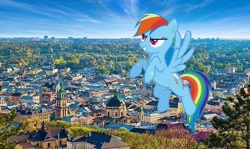Size: 845x503 | Tagged: safe, edit, screencap, rainbow dash, pegasus, pony, g4, the ticket master, female, flying, giant pony, irl, lviv, macro, mare, photo, ponies in real life, solo, spread wings, ukraine, wings