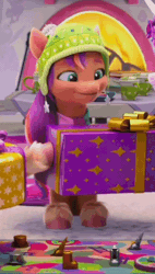 Size: 370x652 | Tagged: safe, screencap, sunny starscout, earth pony, pony, g5, my little pony: make your mark, my little pony: make your mark chapter 3, winter wishday, spoiler:g5, spoiler:winter wishday, animated, board game, cropped, cute, female, fireplace, gif, hat, mane stripe sunny, mare, mouth hold, open mouth, present, sitting, sunnybetes