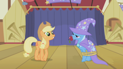 Size: 1000x563 | Tagged: safe, edit, edited screencap, screencap, applejack, trixie, earth pony, pony, unicorn, boast busters, g4, season 1, alternate scenario, apple, apple gag, brooch, cape, clothes, duo, duo female, female, food, frown, gag, gem, grin, hat, jewelry, karma, looking at someone, mare, rope, silly, smiling, stage, stars, tied up, trixie is not amused, trixie's brooch, trixie's cape, trixie's hat, unamused