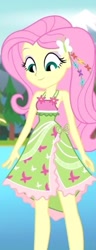 Size: 208x544 | Tagged: safe, screencap, fluttershy, equestria girls, g4, my little pony equestria girls: better together, my little pony equestria girls: legend of everfree, armpits, bare shoulders, boho, camp fashion show outfit, clothes, dress, eyeshadow, grin, hairpin, looking at self, makeup, mountain, pond, sleeveless, smiling, solo, tree, water