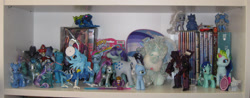 Size: 1144x450 | Tagged: safe, applejack (g1), coloratura, diamond mint, hopscotch, lyra heartstrings, seaspray, silver spoon, trixie, earth pony, unicorn, g1, g3, g4, bootleg, concerned pony, dvd, female, fluppy dogs, irl, lanyi, male, mare, my lovely horse, photo, pony land, shelf, toy, transformers, water cuties, ʞɔɐɾǝlddɐ