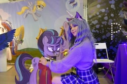 Size: 828x552 | Tagged: safe, artist:hysteriana, derpy hooves, izzy moonbow, snowfall frost, starlight glimmer, human, pegasus, pony, unicorn, g4, g5, ball, blue hair, boop, brony, choker, clothes, cosplay, costume, female, festival, irl, irl human, izzy's tennis ball, legs, photo, schoolgirl, skirt, solo, starlight glimmer is not amused, sweater, tennis ball, unamused