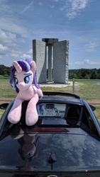 Size: 2160x3840 | Tagged: safe, starlight glimmer, pony, unicorn, g4, car, chain link fence, cloud, elbert county, female, fence, georgia (state), georgia guidestones, granite, grass, high res, irl, lidded eyes, lying down, mare, monument, photo, plushie, ponies around the world, prone, solo, tree