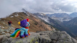 Size: 1192x670 | Tagged: safe, rainbow dash, human, pegasus, pony, g4, clothes, female, hat, irl, mare, mountain, photo, plushie, ponies around the world, ponies in real life, scarf, socks