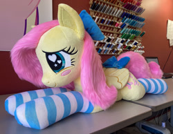 Size: 2336x1814 | Tagged: safe, artist:qtpony, fluttershy, pegasus, pony, g4, bow, clothes, cute, female, folded wings, hair bow, irl, lying down, photo, plushie, prone, quadrupedal, shyabetes, socks, solo, striped socks, wings