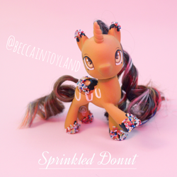 Size: 2048x2048 | Tagged: safe, artist:beccaintoyland, oc, oc:sprinkled donut, pony, unicorn, g4, g4.5, body markings, brown coat, brown hair, brown mane, chocolate, colored hooves, curly mane, customized toy, donut, food, high res, irl, multicolored mane, orange eyes, photo, pink mane, repaint, sprinkles, toy