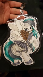 Size: 1152x2048 | Tagged: safe, artist:inkkeystudios, oc, oc only, pony, badge, bedroom eyes, clothes, duster, garter, garter belt, garter straps, lidded eyes, looking at you, maid, mouth hold, photo, solo, spread wings, traditional art, underhoof, wings