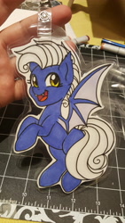 Size: 5312x2988 | Tagged: safe, artist:inkkeystudios, oc, oc only, bat pony, pony, badge, fangs, looking at you, open mouth, open smile, photo, smiling, solo, spread wings, traditional art, wings