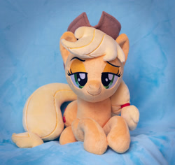 Size: 2939x2780 | Tagged: safe, artist:buttercupbabyppg, applejack, earth pony, pony, g4, applejack's hat, cowboy hat, female, hair tie, hat, high res, irl, lidded eyes, lying down, mare, photo, plushie, prone, solo