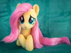 Size: 1852x1371 | Tagged: safe, artist:buttercupbabyppg, fluttershy, pegasus, pony, g4, cute, female, folded wings, irl, lying down, mare, photo, plushie, prone, shyabetes, smiling, solo, wings