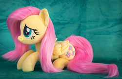 Size: 2227x1434 | Tagged: safe, artist:buttercupbabyppg, fluttershy, pegasus, pony, g4, cute, female, folded wings, irl, lying down, mare, photo, plushie, prone, shyabetes, smiling, solo, wings