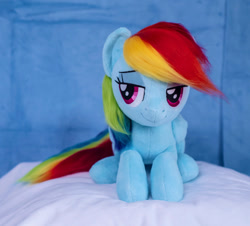 Size: 1026x928 | Tagged: safe, artist:buttercupbabyppg, rainbow dash, pegasus, pony, g4, female, folded wings, irl, lying down, mare, photo, plushie, prone, smiling, solo, wings