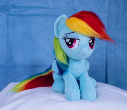 Size: 1098x948 | Tagged: safe, artist:buttercupbabyppg, rainbow dash, pegasus, pony, g4, female, folded wings, irl, lying down, mare, photo, plushie, prone, smiling, solo, wings