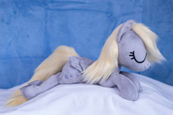 Size: 1511x1010 | Tagged: safe, artist:buttercupbabyppg, derpy hooves, pegasus, pony, g4, eyes closed, female, folded wings, happy, irl, lying down, mare, photo, plushie, prone, sleeping, wings