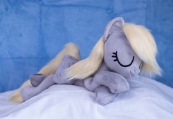 Size: 1382x950 | Tagged: safe, artist:buttercupbabyppg, derpy hooves, pegasus, pony, g4, eyes closed, female, folded wings, happy, irl, lying down, mare, photo, plushie, prone, sleeping, wings