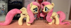 Size: 2048x806 | Tagged: safe, artist:rtryart, fluttershy, pegasus, pony, g4, duo, female, folded wings, irl, mare, photo, plushie, smiling, standing, wings