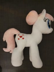 Size: 240x320 | Tagged: safe, artist:melodisde, nurse redheart, earth pony, pony, g4, bun, female, happy, irl, mare, photo, plushie, smiling, solo, standing