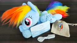 Size: 15538x8771 | Tagged: safe, rainbow dash, pegasus, pony, g4, cute, embroidery, happy, irl, looking at you, lying down, photo, plushie, pony plushie, smiling, smiling at you, wonderbolts