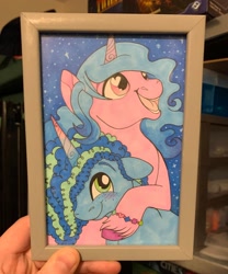 Size: 1702x2048 | Tagged: safe, artist:reskell492, izzy moonbow, misty brightdawn, human, pony, unicorn, g5, blushing, female, hand, heart, heart eyes, hug, irl, irl human, lesbian, mare, night, night sky, photo, picture frame, ship:mizzy, shipping, sky, starry background, stars, traditional art, unshorn fetlocks, wingding eyes