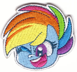 Size: 1050x984 | Tagged: safe, rainbow dash, pegasus, pony, g4, g4.5, my little pony: pony life, official, 2d, chibi, looking at you, merchandise, one eye closed, patch, photo, solo, wink, winking at you