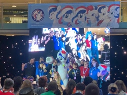 Size: 2048x1536 | Tagged: safe, oc, oc:britannia (uk ponycon), human, uk ponycon, 2024, fursuit, group photo, irl, irl human, photo, ponysuit, stage