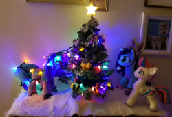 Size: 1792x1228 | Tagged: safe, artist:melodis, izzy moonbow, misty brightdawn, zipp storm, pegasus, pony, unicorn, g5, animal costume, christmas, christmas decoration, christmas lights, christmas tree, costume, decoration, female, holiday, horn, irl, looking at each other, looking at someone, mare, photo, plushie, reindeer costume, tangled up, tree, trio, trio female