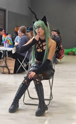 Size: 581x951 | Tagged: safe, artist:hysteriana, queen chrysalis, changeling, human, g4, boots, breasts, chair, clothes, cosplay, costume, female, festival, goth, green hair, green mane, hole, holes, horn, humanized, irl, irl human, leather, leather boots, long hair, looking at someone, necklace, open mouth, pentagram, photo, shoes, sitting, skirt, stockings, thigh highs, tight clothing, top
