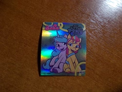 Size: 1024x768 | Tagged: safe, izzy moonbow, sunny starscout, earth pony, unicorn, g5, official, 2d, berry, food, fruit, horn, indonesian, looking at each other, looking at someone, merchandise, photo, shiny, sitting, smiling, sticker, together, together forever