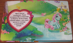 Size: 800x468 | Tagged: safe, egmont, minty, butterfly, earth pony, pony, g3, official, 2d, book, cyrillic, flower, heart, jigsaw puzzle, lake, looking at you, photo, ribbon, russian, sitting, smiling, smiling at you, tent, translated in the description, water, waterlily