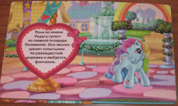 Size: 800x481 | Tagged: safe, egmont, rainbow dash (g3), earth pony, pony, g3, book, cyrillic, fountain, heart, house, jigsaw puzzle, looking at you, page, photo, ribbon, russian, smiling, smiling at you, standing, translated in the description