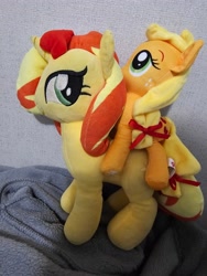 Size: 3000x4000 | Tagged: safe, photographer:professorventurer, applejack, sunset shimmer, earth pony, pony, unicorn, g4, applejack riding sunset shimmer, appletini, horn, irl, looking left, micro, photo, plushie, ponies riding ponies, riding