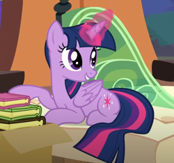 Size: 628x589 | Tagged: safe, screencap, twilight sparkle, alicorn, pony, g4, trade ya!, book, box, cropped, folded wings, friendship express, glowing, glowing horn, horn, locomotive, lying down, prone, smiling, solo, steam locomotive, train, twilight sparkle (alicorn), wings