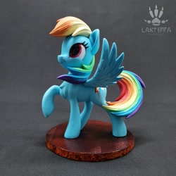 Size: 2560x2560 | Tagged: safe, alternate angle, alternate version, artist:lakterra, rainbow dash, pegasus, pony, g4, craft, female, figurine, irl, looking up, mare, photo, polymer clay, raised hoof, signature, smiling, solo, spread wings, stand, tail, wings