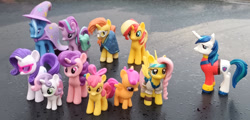 Size: 1280x614 | Tagged: safe, artist:dingopatagonico, apple bloom, fluttershy, rarity, scootaloo, shining armor, starlight glimmer, sugar belle, sunburst, sunset shimmer, sweetie belle, trixie, earth pony, pegasus, pony, unicorn, g4, cape, clothes, hat, horn, male, photo, pirate costume, stallion, toy, trixie's cape, trixie's hat