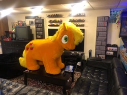 Size: 2048x1536 | Tagged: safe, applejack, g4, bookshelf, carpet, couch, fursuit, indoors, irl, photo, playstation, playstation 5, ponysuit, quadsuit, remote control, side view, solo, spookyjack, table, television